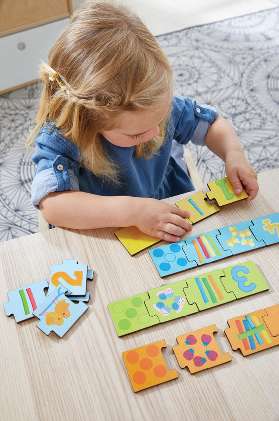 Girl completing HABA Matching Puzzle Numbers